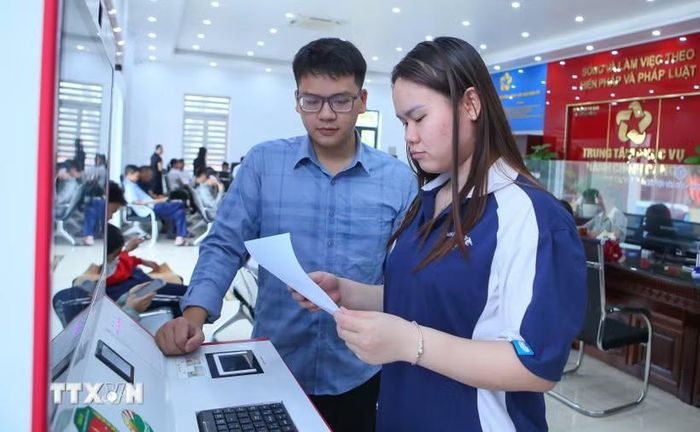 Cán bộ Trung tâm Phục vụ hành chính công xã Rạng Đông hướng dẫn người dân thực hiện thao tác tại Kiosk hành chính công. (Ảnh: Công Luật/TTXVN)