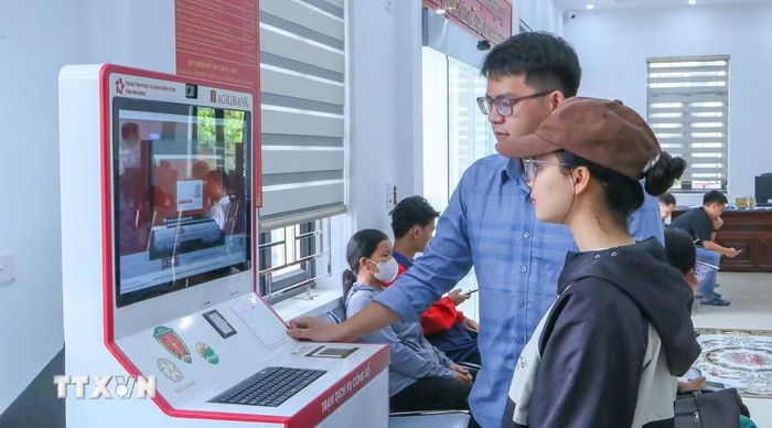 Cán bộ Trung tâm Phục vụ hành chính công xã Rạng Đông hướng dẫn người dân thực hiện thao tác tại Kiosk hành chính công. (Ảnh: Công Luật/TTXVN)