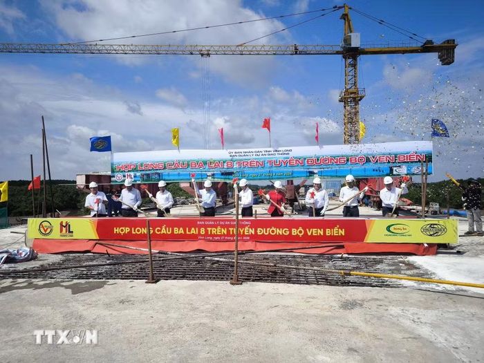 Đại biểu thực hiện nghi thức hợp long cầu Ba Lai 8. (Ảnh: Huỳnh Phúc Hậu/TTXVN)