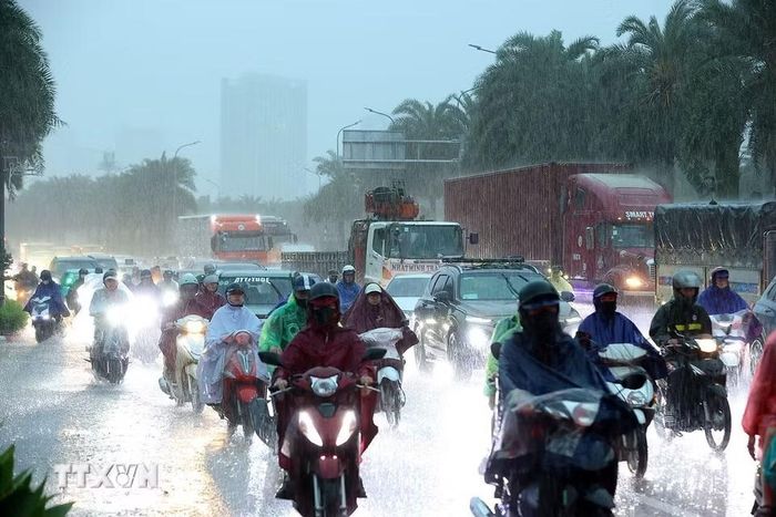 Mưa lớn vào đúng giờ cao điểm khiến các phương tiện tham gia giao thông khó khăn. (Ảnh: Văn Điệp/TTXVN)