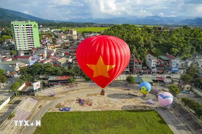 Khinh khí cầu mang hình ảnh Quốc kỳ Việt Nam nổi bật giữa nền trời xanh và cảnh quan phường Điện Biên Phủ. (Ảnh: Xuân Tư/TTXVN)