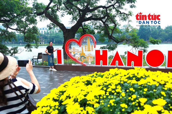 Người dân vui tươi chụp ảnh với cụm hình "Tôi yêu Hà Nội" tại hồ Hoàn Kiếm.