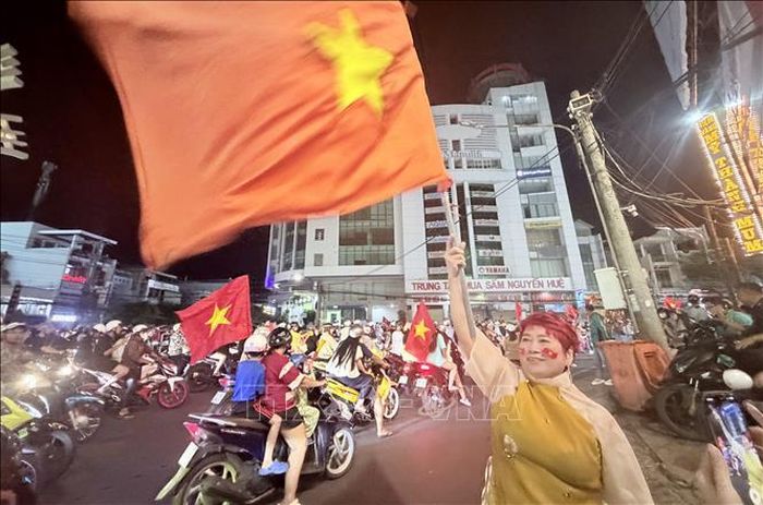 Người dân vẫy cờ Tổ quốc, hòa chung không khí mừng chiến thắng của đội tuyển Việt Nam. Ảnh: Thanh Sang/TTXVN