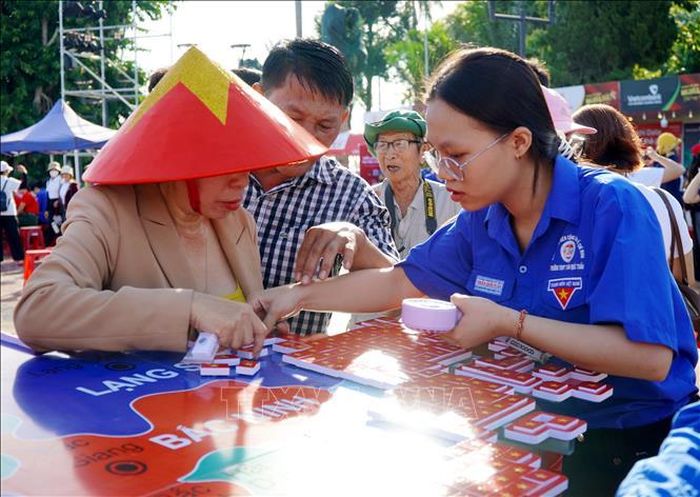 Đông đảo cán bộ, đoàn viên, thanh niên và người dân tham gia ghép bản đồ Việt Nam từ 8.100 lá cờ Tổ quốc.