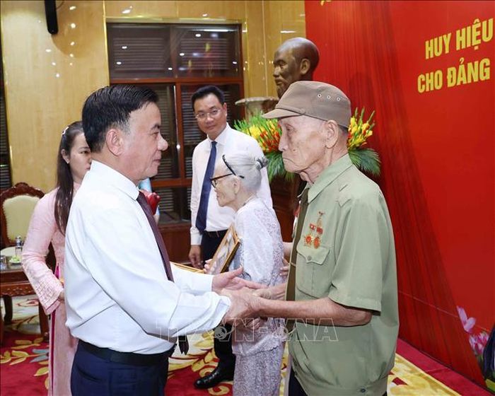 Thường trực Ban Bí thư Trần Cẩm Tú trao Huy hiệu 80 năm tuổi Đảng cho đảng viên lão thành Hồ Văn Lang. Ảnh: Phương Hoa/TTXVN