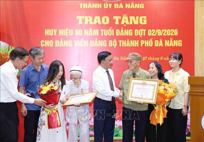 Thường trực Ban Bí thư Trần Cẩm Tú cùng gia đình đảng viên lão thành Nguyễn Thị Hữu và Hồ Văn Lang, Đảng bộ thành phố Đà Nẵng. Ảnh: Phương Hoa/TTXVN