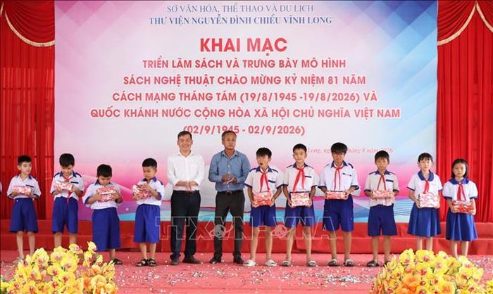 Ban Tổ chức trao quà cho học sinh vượt khó học giỏi tại lễ khai mạc triển lãm.