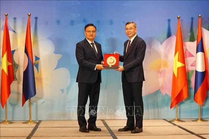 Phó Thủ tướng, Bộ trưởng Bộ Tài chính Lào Santiphab Phomvihane (bên trái) tặng quà lưu niệm cho Bộ trưởng Bộ Tài chính Việt Nam Ngô Văn Tuấn. Ảnh: Quốc Dũng/TTXVN