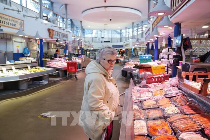 Người tiêu dùng mua sắm tại chợ ở Manchester, Anh. Ảnh: THX/TTXVN phát