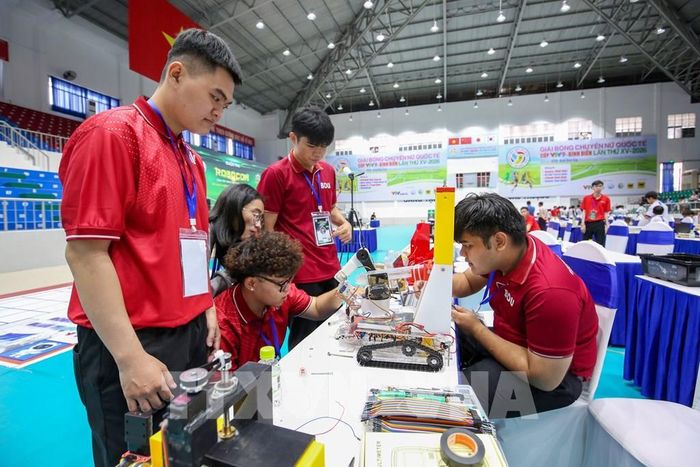 Học sinh phối hợp, trao đổi phương án lập trình và điều khiển robot, qua đó nâng cao kỹ năng làm việc nhóm và giải quyết vấn đề. Ảnh: Giang Phương - TTXVN
