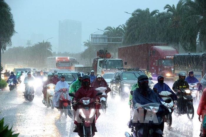 Mưa lớn vào đúng giờ cao điểm khiến các phương tiện tham gia giao thông khó khăn. Ảnh: Văn Điệp - TTXVN