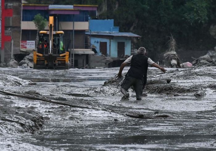 Một người dân đi dọc con đường đầy bùn ở quận Nuwakot, Nepal. Ảnh: Prakash Mathema/AFP/Getty Images