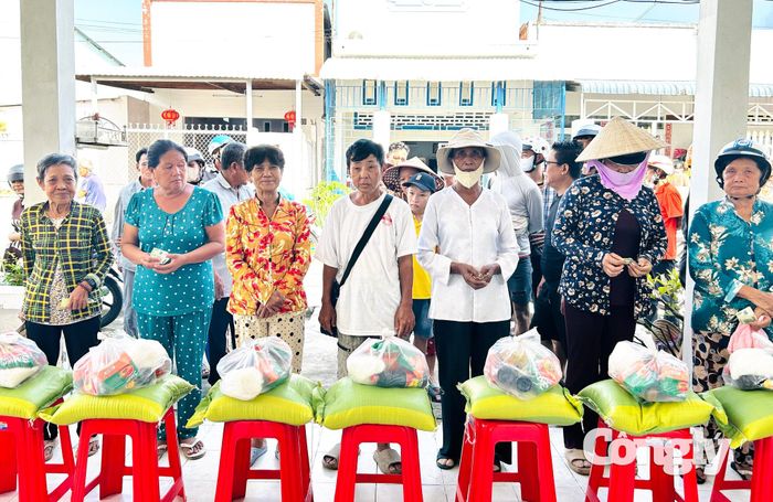 Đại diện Công ty CP Đầu tư và Thẩm định giá Sao Việt - Chi nhánh Tây Đô và Công ty TNHH Đo đạc và Dịch vụ Đất Mới trao quà cho người dân.