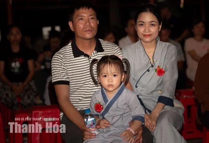 Gia đình nhỏ bên nhau ngày lễ, những cánh hồng đỏ trên ngực áo là minh chứng cho niềm hạnh phúc mộc mạc mà đủ đầy.