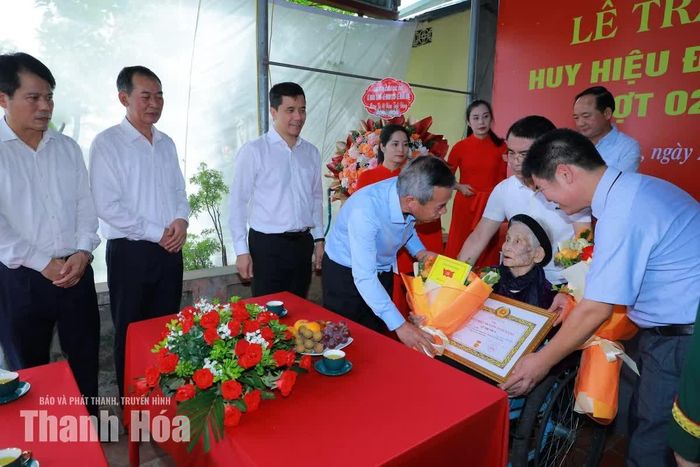 Bí thư Tỉnh ủy Lê Đức Thái tặng hoa và quà chúc mừng đảng viên Lê Thị Thủy.