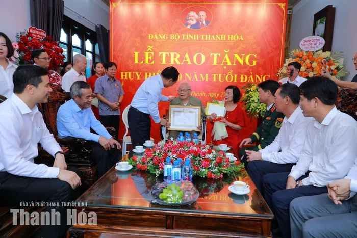 Trưởng Ban Tuyên giáo Trung ương Trịnh Văn Quyết trao Huy hiệu 80 năm tuổi Đảng cho ông Trịnh Khắc Thuần, sinh năm 1927, ở số nhà 11 phố Đỗ Hành, phường Hạc Thành.