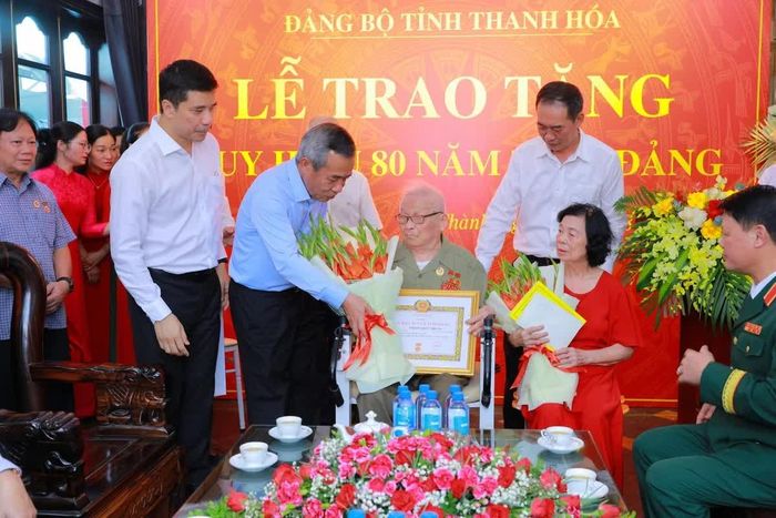 Bí thư Tỉnh ủy Lê Đức Thái tặng hoa và quà chúc mừng đảng viên Trịnh Khắc Thuần.