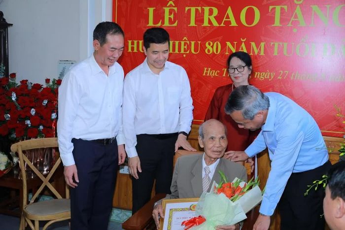 Bí thư Tỉnh ủy Lê Đức Thái tặng hoa và quà chúc mừng đảng viên Nguyễn Xuân Trớc.