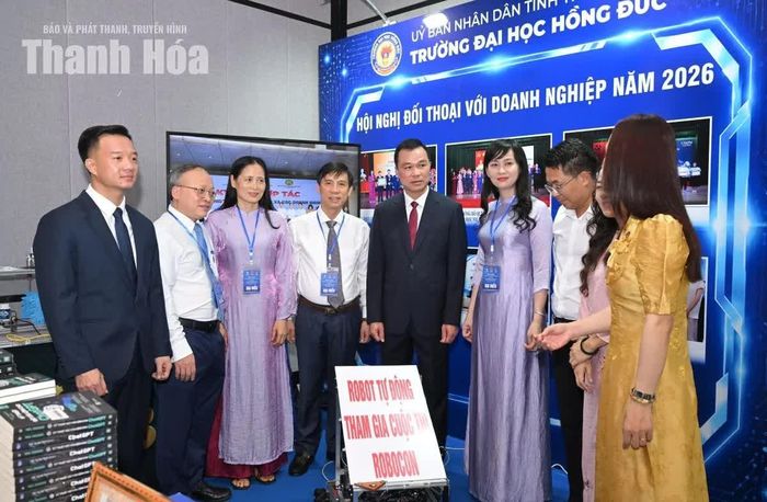 Chủ tịch UBND tỉnh Tô Anh Dũng và các đại biểu tham quan gian hàng trưng bày của Trường Đại học Hồng Đức.