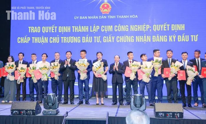 Các đồng chí Ủy viên Ban Thường vụ Tỉnh ủy: Phó Chủ tịch Thường trực HĐND tỉnh Lê Tiến Lam, Phó Chủ tịch Thường trực UBND tỉnh Mai Xuân Liêm trao Quyết định và tặng hoa chúc mừng các doanh nghiệp.