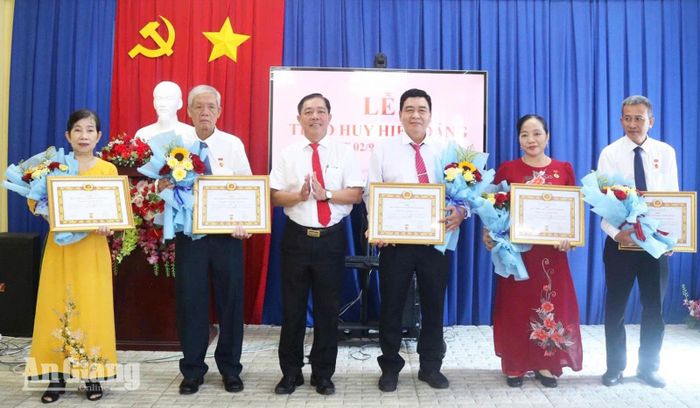 Bí thư Đảng ủy, Chủ tịch HĐND xã Trần Tấn Phương trao Huy hiệu Đảng cho các đảng viên.