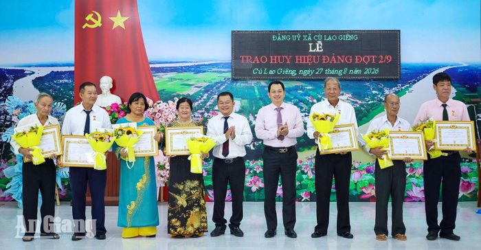 Bí thư Đảng ủy, Chủ tịch HĐND xã Cù Lao Giêng Võ Minh Nâng (thứ tư, từ phải qua) trao Huy hiệu 35 năm tuổi Đảng cho các đảng viên.