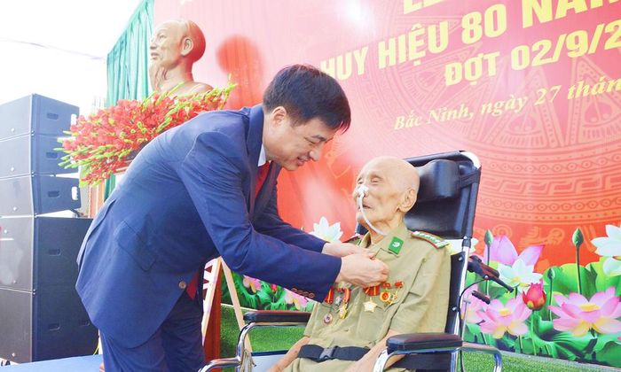  Đồng chí Trưởng Ban Tổ chức Trung ương gắn Huy hiệu Đảng cho đảng viên Đỗ Việt Hưng. 