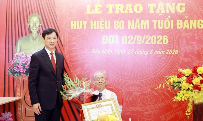  Đồng chí Nguyễn Duy Ngọc trao tặng Huy hiệu và tặng hoa chúc mừng đảng viên Nguyễn Thanh Mậu. 