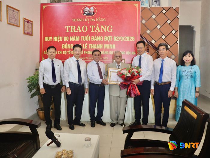 Thường trực Ban Bí thư Trần Cẩm Tú (thứ 3, từ trái sang) và lãnh đạo thành phố Đà Nẵng trao Huy hiệu 80 năm tuổi Đảng, tặng hoa chúc mừng đảng viên lão thành Lê Thanh Minh. Ảnh: QUỐC TUẤN