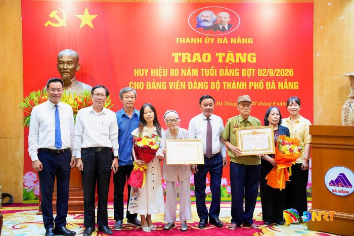 Các đại biểu chụp ảnh lưu niệm với các đảng viên và gia đình. Ảnh: T.CÔNG