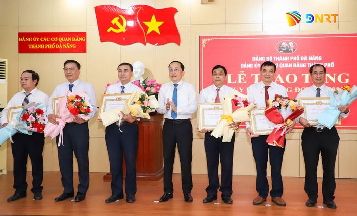 Phó Bí thư Đảng ủy Các cơ quan Đảng thành phố Nguyễn Văn Lượm (thứ 4, bên phải sang) trao Huy hiệu 35 năm tuổi Đảng cho các đảng viên đủ tiêu chuẩn. Ảnh: NGỌC PHÚ