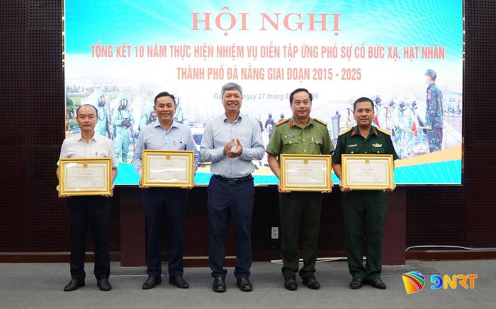Phó Chủ tịch UBND thành phố Hồ Quang Bửu trao bằng khen của Chủ tịch UBND thành phố cho 4 tập thể có thành tích xuất sắc trong thực hiện nhiệm vụ diễn tập ứng phó sự cố bức xạ và hạt nhân giai đoạn 2015 - 2025. Ảnh: VINH ANH