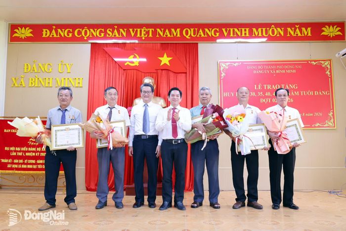 Bí thư Đảng ủy, Chủ tịch HĐND xã Bình Minh Nguyễn Kim Phước trao Huy hiệu Đảng cho các đảng viên. Ảnh: Thanh Tâm