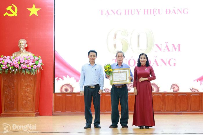 Lãnh đạo Đảng ủy xã trao Huy hiệu 60 năm tuổi Đảng cho đảng viên. Ảnh: Vũ Nguyện