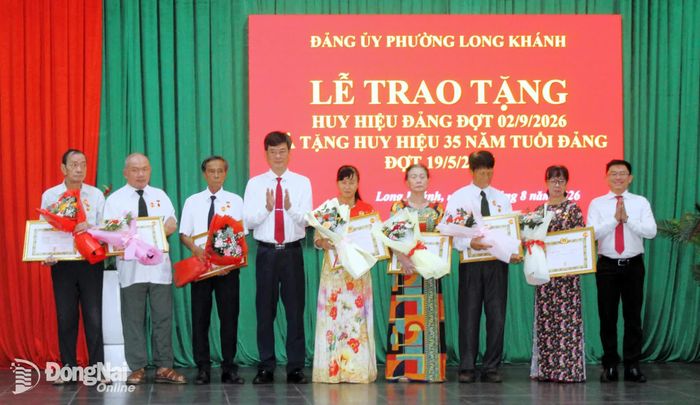 Bí thư Đảng ủy phường Long Khánh Nguyễn Quang Phương trao Huy hiệu Đảng cho các đảng viên. Ảnh: Danh Lộc
