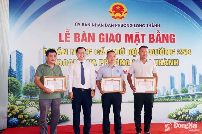 Chủ tịch UBND phường Long Thành Lê Hoàng Sơn khen thưởng các tập thể, cá nhân có thành tích xuất sắc trong công tác bồi thường, giải phóng mặt bằng dự án. Ảnh: Phạm Tùng