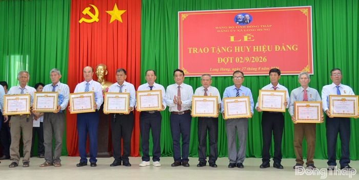 Đồng chí Nguyễn Minh Quân, Bí thư Đảng ủy, Chủ tịch HĐND xã Long Hưng, trao Huy hiệu Đảng cho các đảng viên.