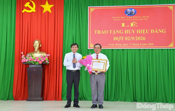 Đồng chí Nguyễn Văn Mười trao Huy hiệu 35 năm tuổi Đảng cho đồng chí Võ Văn Bình.