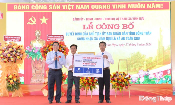 Đồng chí Trần Thanh Nguyên trao biểu trưng bảo hiểm y tế toàn dân xã Vĩnh Hựu.