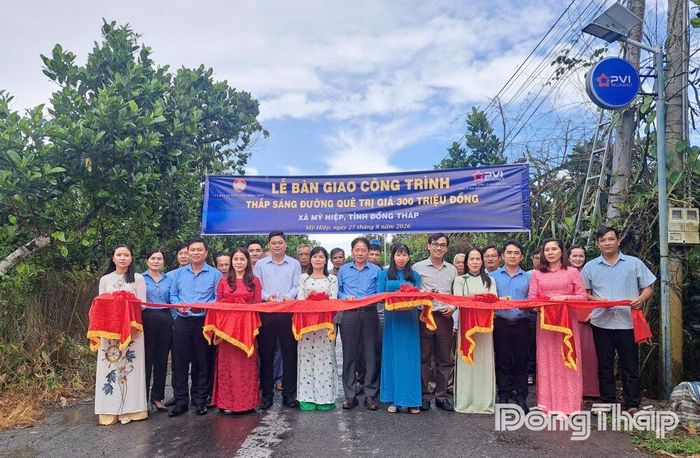 Các đại biểu thực hiện nghi thức khánh thành, đưa vào sử dụng công trình “Thắp sáng đường quê” tại xã Mỹ Hiệp.