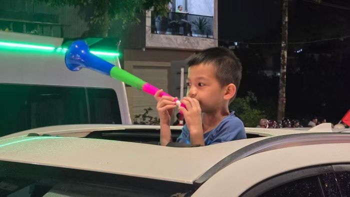 Trong không khí cuồng nhiệt của đêm mừng chiến thắng, nhiều gia đình cũng đã đưa theo con nhỏ ra đường để cùng hòa vào niềm vui chung và ghi lại những khoảnh khắc đáng nhớ. Ảnh: Hoàng Hoài