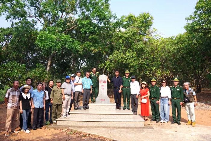  Đoàn văn nghệ sĩ, nhà báo cùng các cán bộ, chiến sĩ Đồn Biên phòng Ia O tại cột mốc biên giới do Đồn phụ trách. Ảnh: Đ.L 