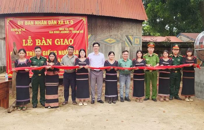 Lãnh đạo Đảng ủy, UBND xã Ia O và chỉ huy các đơn vị, nhà tài trợ cắt băng khánh thành giếng nước sạch. Ảnh: N.S