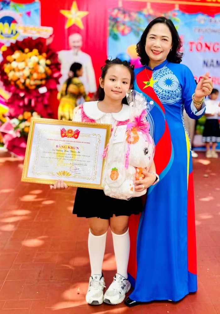 Cô Bùi Thị Phương Hoa - Hiệu trưởng Trường Tiểu học Nguyễn Văn Trỗi, động viên và chúc mừng Thiên An sau khi em đạt giải tại các cuộc thi vẽ tranh cấp quốc gia. Ảnh: NVCC