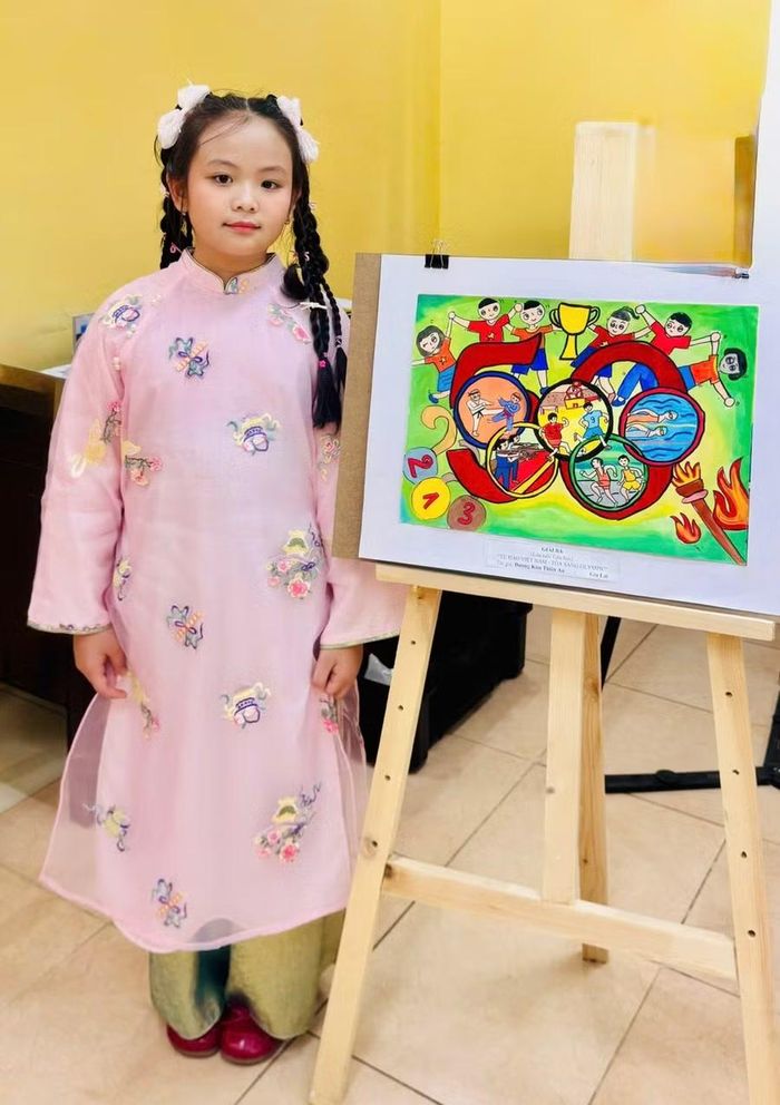 Thiên An bên tác phẩm giúp em giành giải ba Cuộc thi Vẽ tranh “Sắc màu Olympic Việt Nam - 50 năm Tự hào và Khát vọng”. Ảnh: NVCC