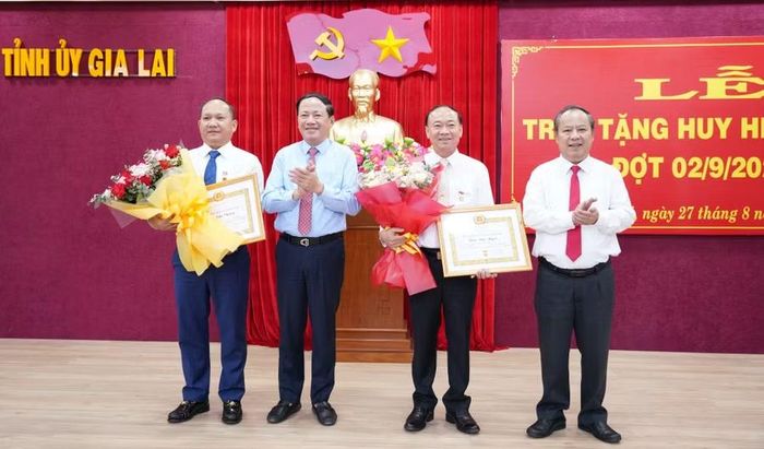 Đồng chí Phạm Anh Tuấn - Ủy viên Ban Chấp hành Trung ương Đảng, Phó Bí thư Tỉnh ủy, Chủ tịch UBND tỉnh (thứ 2 từ trái sang) và đồng chí Châu Ngọc Tuấn - Phó Bí thư Tỉnh ủy, Trưởng Đoàn Đại biểu Quốc hội tỉnh (bên phải) trao Huy hiệu Đảng và tặng hoa chúc mừng 2 đồng chí Thái Đại Ngọc và Rah Lan Chung. Ảnh: N.H