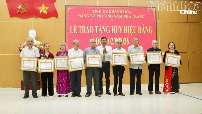 Bí thư Đảng ủy, Chủ tịch HĐND phường Trần Nam Bình trao Huy hiệu 60 năm tuổi Đảng cho các đảng viên.