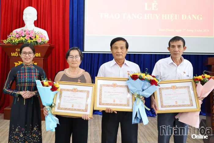 Thường trực Đảng ủy xã Ninh Phước trao Huy hiệu 45 năm tuổi Đảng và tặng hoa chúc mừng các đảng viên.