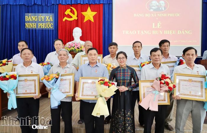 Thường trực Đảng ủy xã Ninh Phước trao Huy hiệu 35 năm tuổi Đảng và tặng hoa chúc mừng các đảng viên.