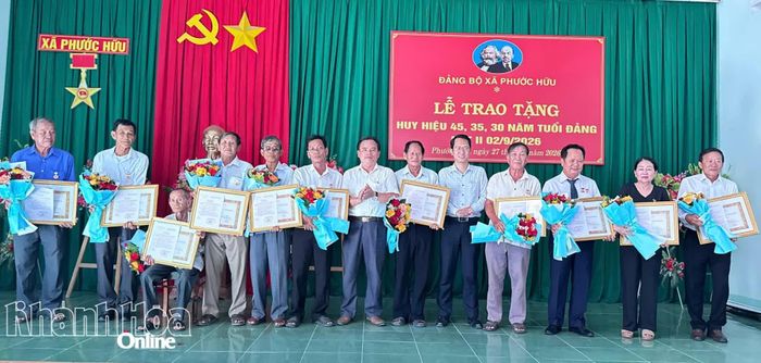 Thường trực Đảng ủy xã Phước Hữu trao Huy hiệu Đảng và tặng hoa chúc mừng các đảng viên.